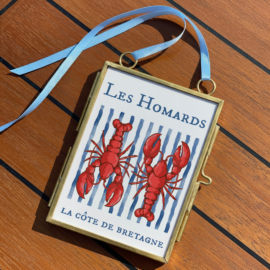Decorative box with lobster design and 'Les Homards' text on a wooden surface